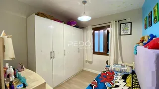 Quarto com armários brancos e cama decorada em Lajeado.