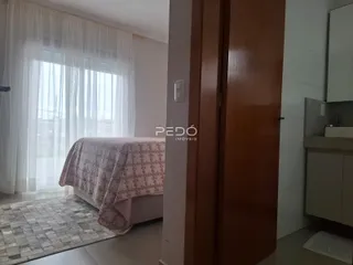 Quarto com janela e cortinas brancas em um imóvel.
