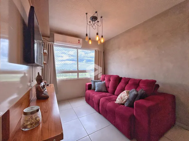 Sala de estar com sofá vermelho e janela de vista para a paisagem.