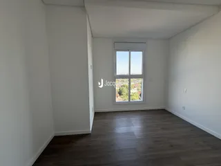 Sala de estar com piso de madeira e grande janela.