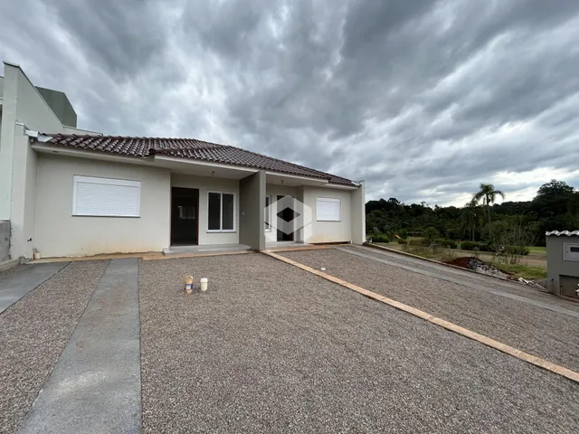 Fachada de uma casa em Lajeado, Brasil, com jardim e entrada pavimentada.