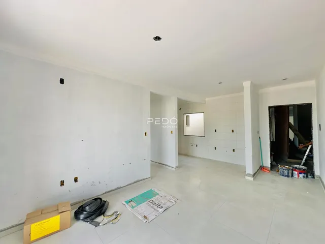 Ambiente interno de uma sala em construção com paredes brancas.