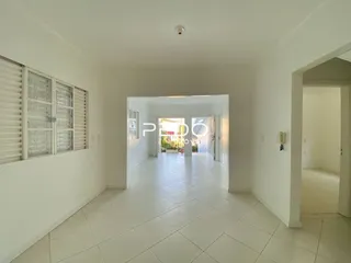 Corredor interno de uma residência com piso de cerâmica clara.