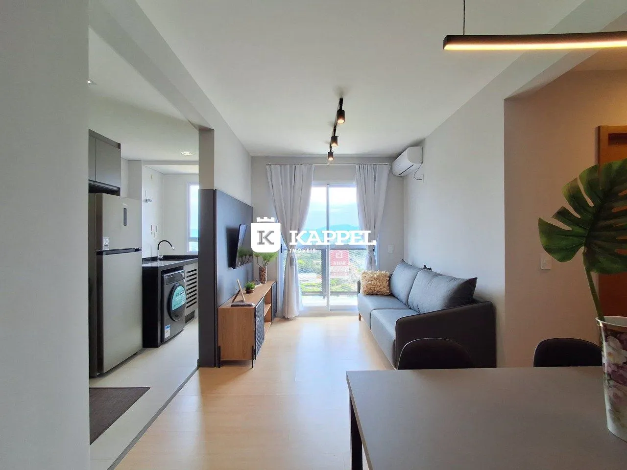 Sala de estar moderna com piso de madeira e iluminação clara.