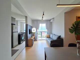 Sala de estar moderna com piso de madeira e iluminação clara.