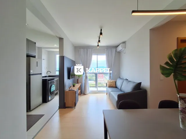 Sala de estar moderna com piso de madeira e iluminação clara.