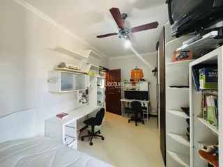 Quarto com cama e armários brancos em ambiente interno.