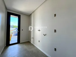 Interior de uma sala com porta de vidro aberta para o exterior.