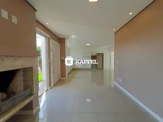 Hall de entrada com piso claro e lareira visível.