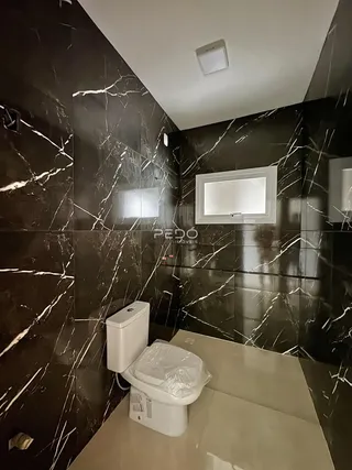 Foto de um banheiro com revestimento de mármore escuro.