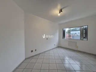 Ambiente interno de uma sala com piso de cerâmica e janela.