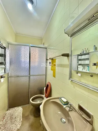 A foto mostra o interior de um banheiro com azulejos amarelos.