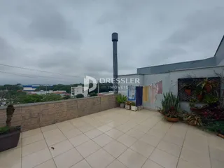 Vista externa de uma área pavimentada adjacente a um edifício.
