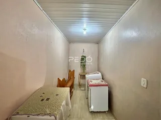 Corredor interno de um imóvel com paredes brancas e teto ripado.