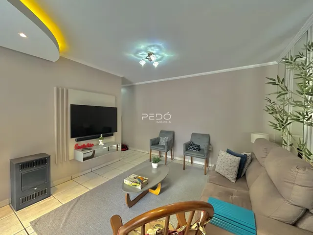 Sala de estar moderna com sofá e poltronas em um ambiente claro.