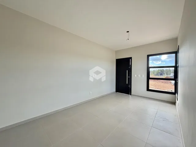 Interior de uma sala ampla com piso de cerâmica e janela.