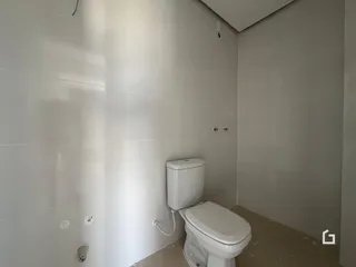 Parede de banheiro com azulejos brancos e um vaso sanitário.