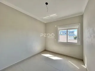 Vista interna de um cômodo com paredes brancas e piso de cerâmica.