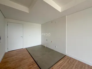 Ambiente interno de uma sala com piso de madeira e área de concreto.