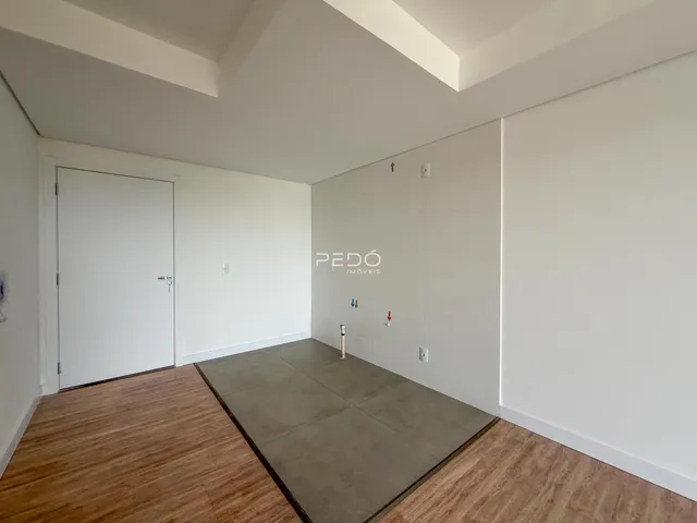 Ambiente interno de uma sala com piso de madeira e área de concreto.