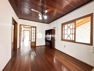 Sala de estar com piso de madeira e teto de madeira exposto.