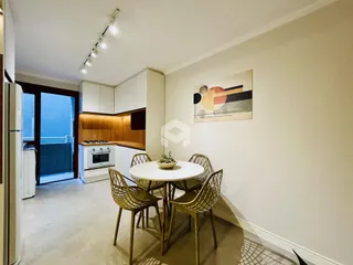 Uma sala de jantar com mesa redonda e cadeiras de vime.