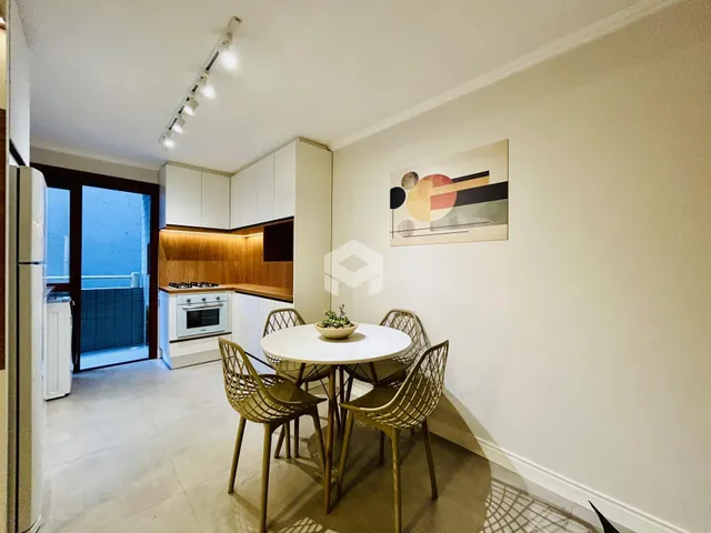 Uma sala de jantar com mesa redonda e cadeiras de vime.