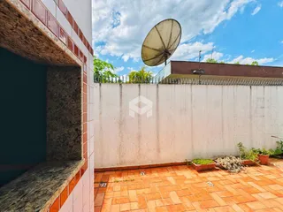 Vista externa de um muro e piso de tijolos em uma propriedade.