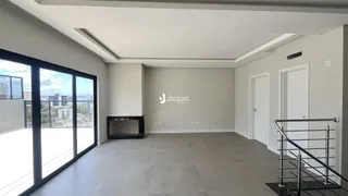 Sala de estar ampla com piso de cerâmica e grandes portas de vidro.