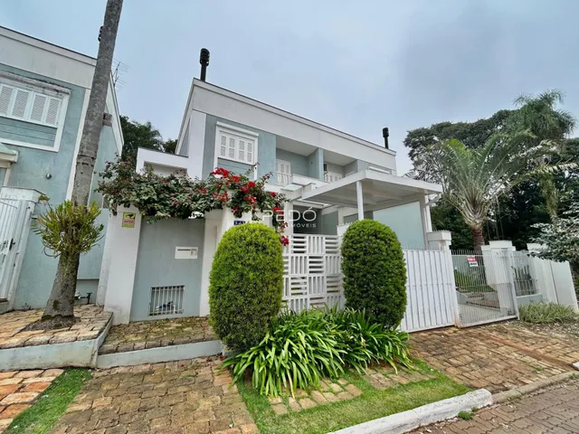 Fachada de uma residência em Lajeado, Brasil, com jardim frontal e cerca branca.