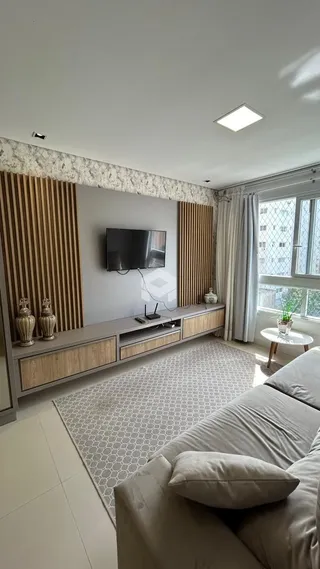 Sala de estar moderna com painéis de madeira e sofá.