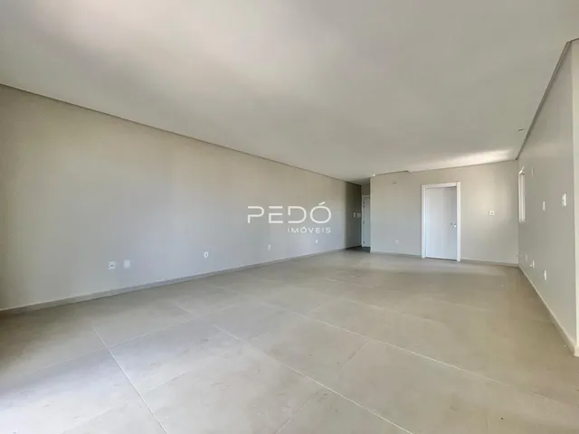 Espaço interno amplo com paredes brancas e piso claro.