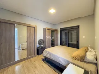 Quarto com armários em madeira e piso de madeira clara.