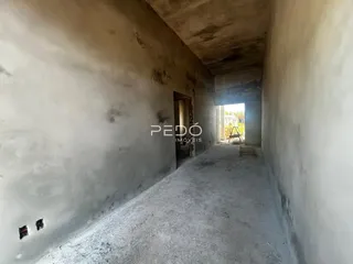 Corredor interno com paredes de concreto aparente.