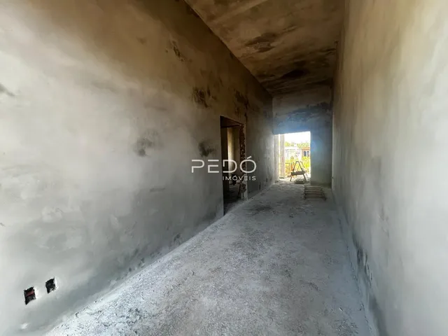 Corredor interno com paredes de concreto aparente.