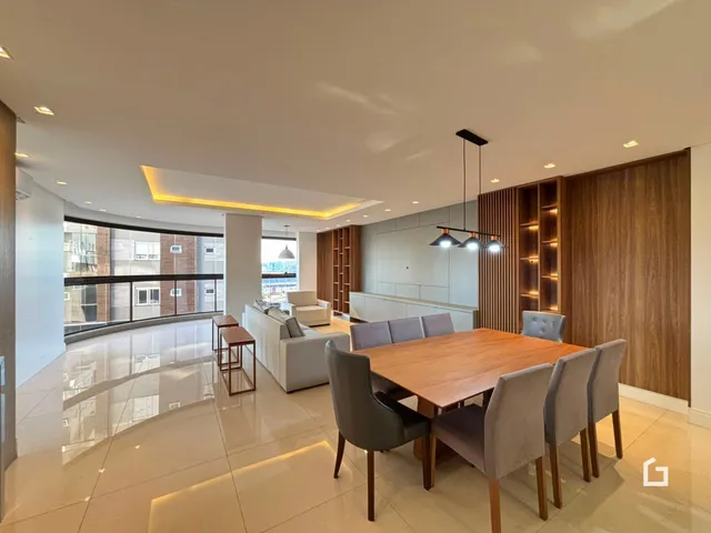 Ambiente de sala de estar e jantar com piso claro e móveis modernos.
