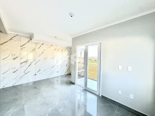 Interior de uma sala com revestimento de mármore branco e piso claro.