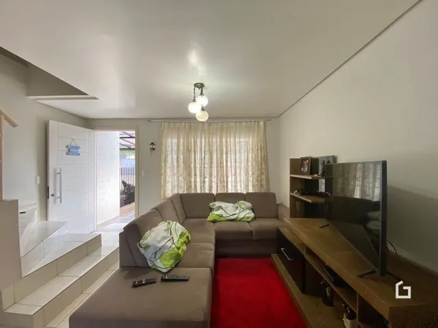 Sala de estar com sofá e parede branca.