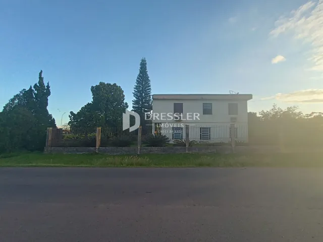 Fachada de uma residência em Lajeado, Brasil, com cerca e vegetação ao redor.