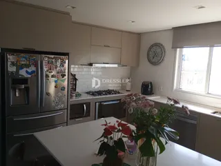 Vista da cozinha moderna com armários e eletrodomésticos em Lajeado.