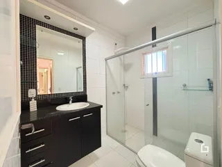 Foto de um banheiro moderno com box de vidro e revestimento branco.