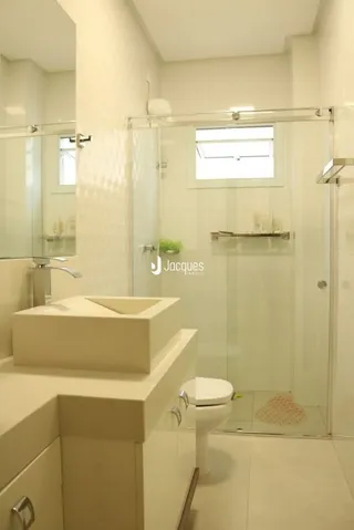 Foto de um banheiro moderno com bancada e box de vidro.
