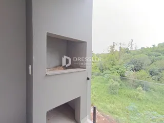 Detalhe arquitetônico de uma parede com abertura e vista para a vegetação externa.