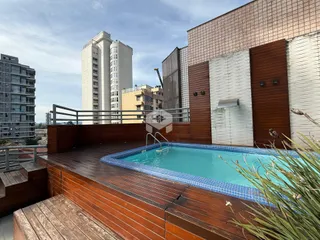 Vista de uma piscina e deck de madeira em uma propriedade.