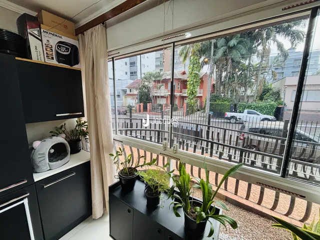 Vista da cozinha com grandes janelões que dão para o exterior.