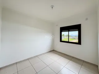 Ambiente interno de uma sala com piso de cerâmica e janela.
