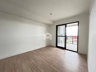 Ambiente interno de uma sala com piso de madeira e porta de vidro.