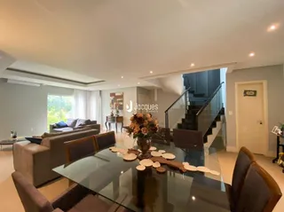Sala de estar moderna com mesa de vidro e sofás.