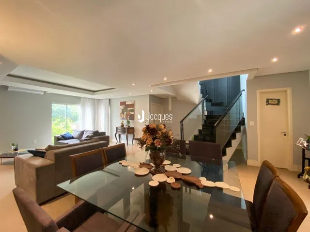 Sala de estar moderna com mesa de vidro e sofás.