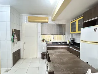Interior da cozinha com piso de cerâmica e paredes brancas.